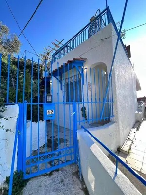 a blue gate on the side of a building at sky inn with wonderful Acropolis view in Neos kosmos in Athens
