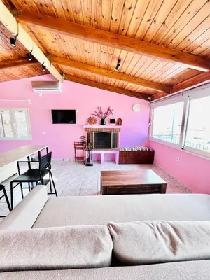 a living room with a pink wall and a couch at sky inn with wonderful Acropolis view in Neos kosmos in Athens