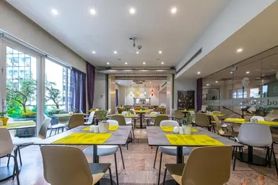 a restaurant with tables and chairs and a cafeteria at Polis Grand Hotel in Athens