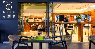 a table and chairs in front of a restaurant at Polis Grand Hotel in Athens
