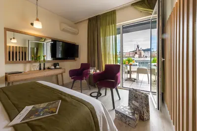 a hotel room with a bed and a balcony at Polis Grand Hotel in Athens