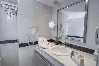 a white bathroom with a sink and a mirror at Polis Grand Hotel in Athens
