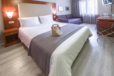 a hotel room with a bed with a bag on it at Polis Grand Hotel in Athens
