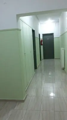an empty room with white cabinets and a tile floor at Alma in Athens