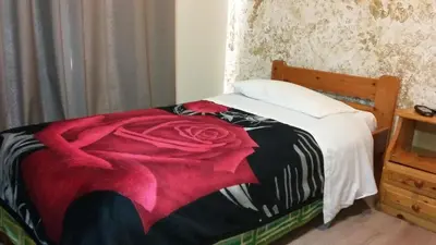 a bedroom with a bed with a red rose on it at Alma in Athens
