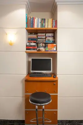 a desk with a computer and a stool at Lilia Hotel in Piraeus