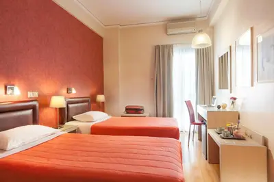 two beds in a hotel room with red walls at Lilia Hotel in Piraeus