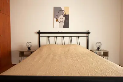 a bed in a bedroom with a picture on the wall at DIMANTHEO in Athens