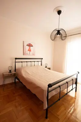 a bed in a bedroom with a chandelier at DIMANTHEO in Athens