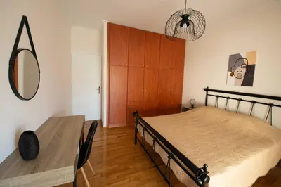 a bedroom with a bed and a table and a mirror at DIMANTHEO in Athens