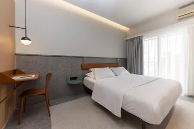 a hotel room with a bed and a desk and a bed sidx sidx at Evripides Hotel in Athens