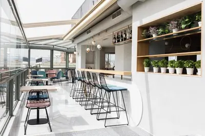 a restaurant with chairs and tables and windows at Evripides Hotel in Athens