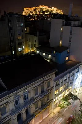 a view of a building in a city at night at Arethusa Hotel Athens in Athens
