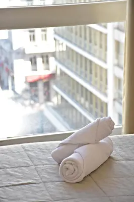 a folded towel sitting on the floor in front of a window at Arethusa Hotel Athens in Athens