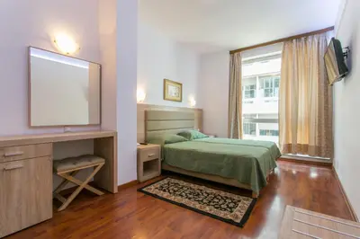 a bedroom with a bed and a flat screen tv at Arethusa Hotel Athens in Athens