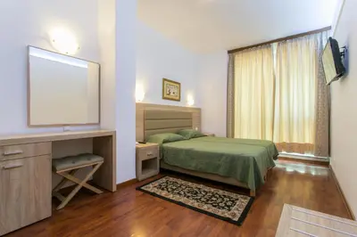 a bedroom with a bed and a flat screen tv at Arethusa Hotel Athens in Athens