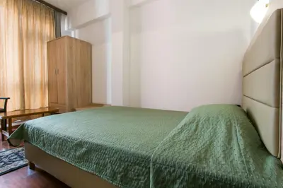 a bedroom with a bed with a green bedspread at Arethusa Hotel Athens in Athens