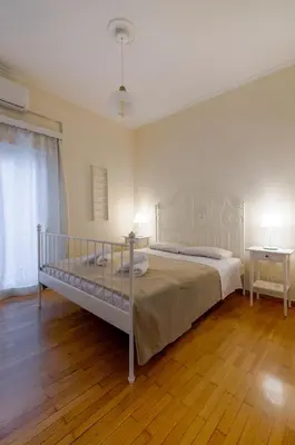 a bedroom with a bed and two tables and a window at Beautiful 2bd apartment near historic center of Athens in Athens