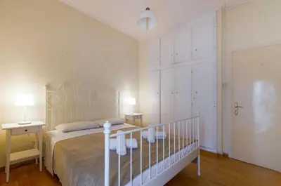 a bedroom with a bed and two tables and two lamps at Beautiful 2bd apartment near historic center of Athens in Athens