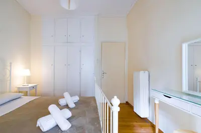 a white bedroom with a bed with white towels at Beautiful 2bd apartment near historic center of Athens in Athens