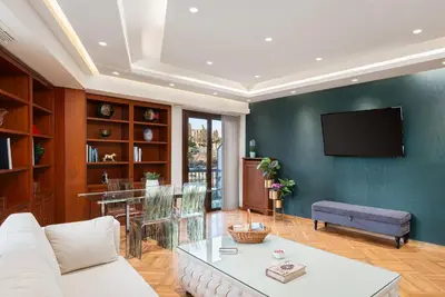 a living room with a white couch and a tv at Acropolis Prestige Residence in Athens