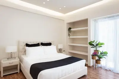 a white bedroom with a large bed and a window at Acropolis Prestige Residence in Athens