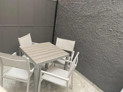 a wooden table and four chairs next to a wall at Monastiraki 112 - 38m2 SuperHost Hub in Athens