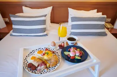 a tray of food and a cup of coffee on a bed at Crystal City Hotel in Athens