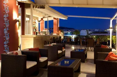 a restaurant with chairs and a bar at night at Crystal City Hotel in Athens
