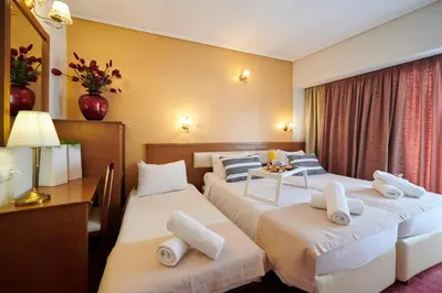 a hotel room with two beds and a table at Crystal City Hotel in Athens