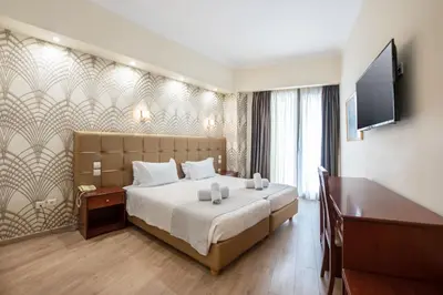 a hotel room with a bed and a flat screen tv at Athens Golden City Hotel in Athens
