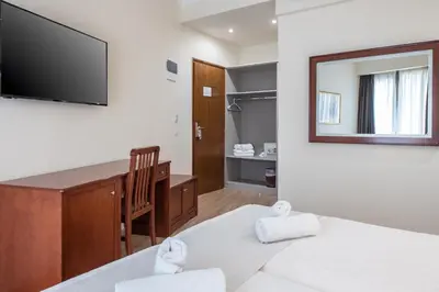 a room with a bed and a desk and a mirror at Athens Golden City Hotel in Athens