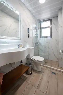 a white bathroom with a sink and a toilet at Athens Golden City Hotel in Athens