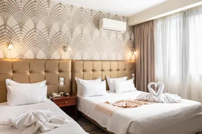 a hotel room with two beds with white sheets at Athens Golden City Hotel in Athens