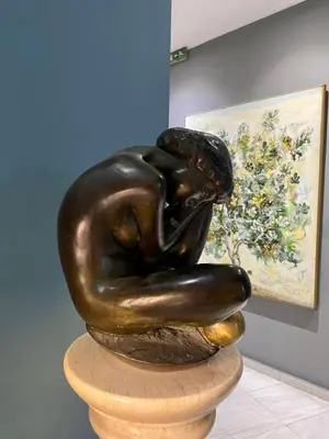 a bronze statue of a woman sleeping on a rock at Art Hotel Athens in Athens