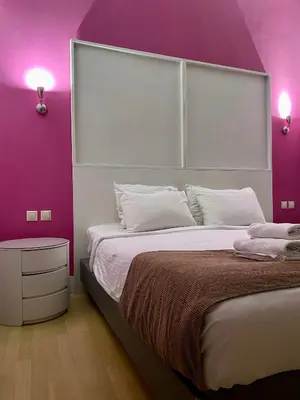 a bedroom with a large bed with purple walls at Art Hotel Athens in Athens