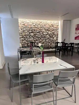 a dining room with a table and chairs and a stone wall at Art Hotel Athens in Athens
