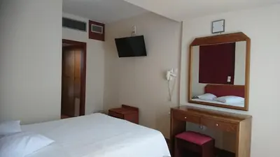 a bedroom with a white bed and a mirror at Economy Hotel in Athens