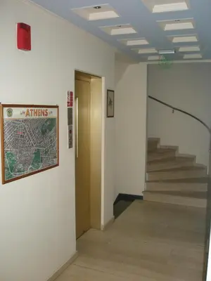a hallway with stairs and a sign on a wall at Economy Hotel in Athens