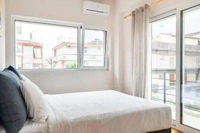 a bedroom with a bed and a large window at Skiathou 12 Contemporary Residences in Athens
