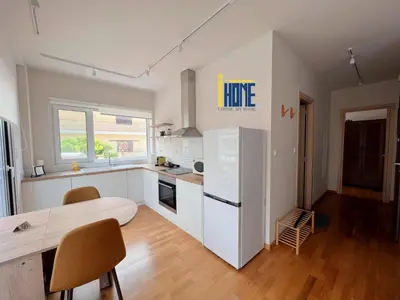 a kitchen with white cabinets and a table and chairs at Skiathou 12 Contemporary Residences in Athens