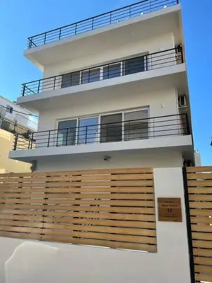 a large white house with a wooden fence at Skiathou 12 Contemporary Residences in Athens