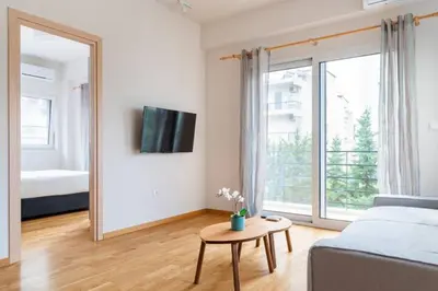 a living room with a mirror and a bed and a table at Skiathou 12 Contemporary Residences in Athens