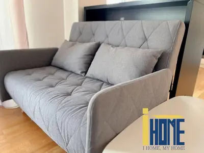 a gray couch in a living room next to a table at Skiathou 12 Contemporary Residences in Athens