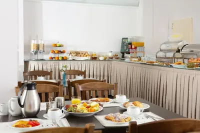 a table with plates of food on top at Attalos Hotel in Athens