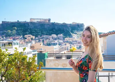 a young woman holding a flower on top of a city at Attalos Hotel in Athens