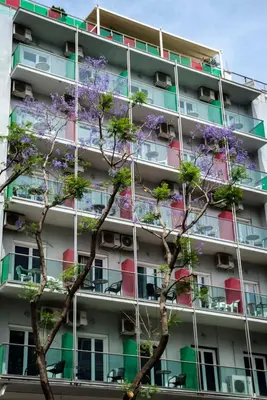 an apartment building with flowering trees in front of it at Attalos Hotel in Athens