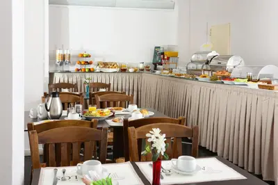 a restaurant with tables and chairs with food on them at Attalos Hotel in Athens