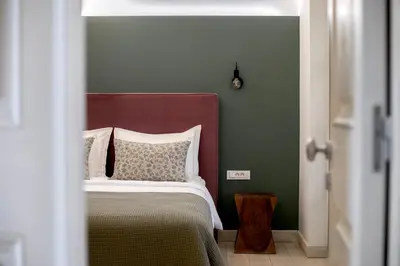 a bedroom with a bed and a green wall at Genesis Grande Acropolis Hill Villa in Athens