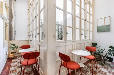 a row of tables and chairs in a room with windows at Genesis Grande Acropolis Hill Villa in Athens